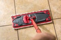 Cleaning the tiles with a floor wiper