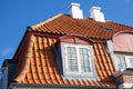 Tiled house roof with chimney and windows. Royalty Free Stock Photo