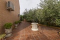Tiled patio of a single family home with large stone planters and a decorative ornamental well