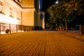 The tiled road in the night green park with lanterns and buildings in summer. Benches in the park during the summer season at Royalty Free Stock Photo