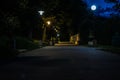 The tiled road in the night green park with lanterns in summer. Benches in the park during the summer season at night. Royalty Free Stock Photo