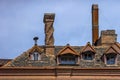 Tiled roof of an old house with skylights and chimneys Royalty Free Stock Photo