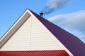 Tiled roof top with chimney with blue cloudy sky in background. Smoke raising from a chimney Royalty Free Stock Photo