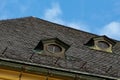 Tiled roof with windows of an old house in europe against the sky Royalty Free Stock Photo