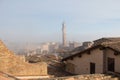 Tiled roofs of Siena and Torre del Mangia in fog on background. Tuscany. Italy.