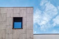 Tiled wall with blue window on cloudy sky