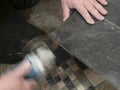 Tiler cuts ceramic tile with disc grinder close up