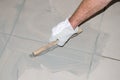 Tiler filling up joints with a rubber squeegee