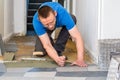 Tiler installing ceramic floor tiles Royalty Free Stock Photo