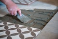 Tiler laying the ceramic tile on the floor. Professional worker makes renovation. Construction Royalty Free Stock Photo