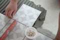 Tiler laying the ceramic tile on the floor. Professional worker makes renovation. Construction. Hands of the tiler