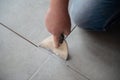 Tiler laying the ceramic tile on the floor. Professional worker makes renovation. Construction. Hands of the tiler Royalty Free Stock Photo