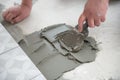 Tiler laying the ceramic tile on the floor. Professional worker makes renovation. Construction. Hands of the tiler Royalty Free Stock Photo