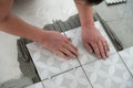 Tiler laying the ceramic tile on the floor. Professional worker makes renovation. Construction. Hands of the tiler Royalty Free Stock Photo