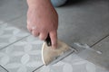 Tiler laying the ceramic tile on the floor. Professional worker makes renovation. Construction. Hands of the tiler. Royalty Free Stock Photo