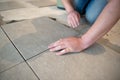 Tiler laying the ceramic tile on the floor. Professional worker makes renovation. Construction. Royalty Free Stock Photo