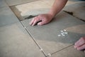 Tiler laying the ceramic tile on the floor. Professional worker makes renovation. Construction. Royalty Free Stock Photo