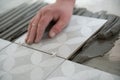 Tiler laying the ceramic tile on the floor. Professional worker makes renovation. Construction. Hands of the tiler Royalty Free Stock Photo