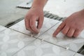 Tiler laying the ceramic tile on the floor. Professional worker makes renovation. Construction. Hands of the tiler Royalty Free Stock Photo