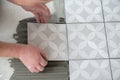 Tiler laying the ceramic tile on the floor. Professional worker makes renovation. Construction. Hands of the tiler Royalty Free Stock Photo