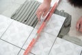 Tiler laying the ceramic tile on the floor. Professional worker makes renovation. Construction. Hands of the tiler Royalty Free Stock Photo