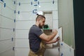 Tiler laying installing ceramic tiles on the wall in the bathroom