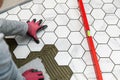 tiler laying marble texture hexagon tiles on the floor