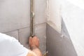The tiler lays a ceramic tile on the wall