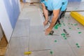 Tiler lays large ceramic floor tiles over a mortar adhesive glue Royalty Free Stock Photo