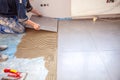 Tiler lays stoneware tiles on the floor