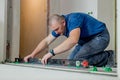 Tiler placing ceramic wall tile in position over adhesive with lash tile leveling system. Ceramic Tiles. Royalty Free Stock Photo