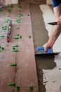 Tiler placing ceramic wall tile in position over adhesive with lash tile leveling system. Ceramic Tiles. Royalty Free Stock Photo