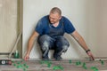 Tiler placing ceramic wall tile in position over adhesive with lash tile leveling system. Ceramic Tiles. Royalty Free Stock Photo