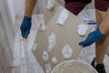 Tiler and plaster repair work laying tile, trowel in a man hand