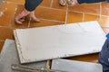 The tiler puts glue on the ceramic tile before laying it
