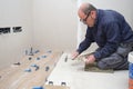 Tiler putting tiles adhesive to the floor with the trowel and notched trowel. Royalty Free Stock Photo