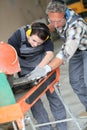 Tiler teaching woman apprentice using thermal grinder