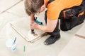 The tiler is using a diamond crown to drill holes in the tile