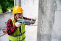 Tiler using electric impact drill to drilling cement wall at unfinished house construction Royalty Free Stock Photo