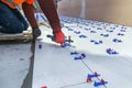 Tiler using plastic clamps and wedges to leveling ceramic tile