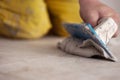 Tilers filling the space between ceramic wood effect tiles