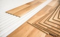 Tiles of light brown laminated floor with wooden effect laying on white base foam, ready to be installed Royalty Free Stock Photo