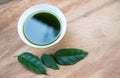 Tiliacora triandra water in a bowl with geen leaf on wood texture