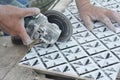 Tiling a bathroom. A man is cutting a bathroom ceramic tile with a disc angle grinder Royalty Free Stock Photo