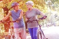 Tilt image of senior couple walking with bicycles in park