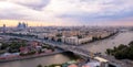 Tilt and shift view of sunset panorama of Moscow with pink clouds, bridge, traveling boats