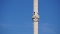 Tilt shot of blue sky and tall two-honored minaret, Islamic buildings and spaces