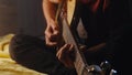 Teen musician playing guitar at night