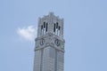 Tilted clock and bell tower in blue sky background