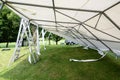 Tilted  event tent during set up and ladders on the lawn in a park for a summer party or wedding Royalty Free Stock Photo
